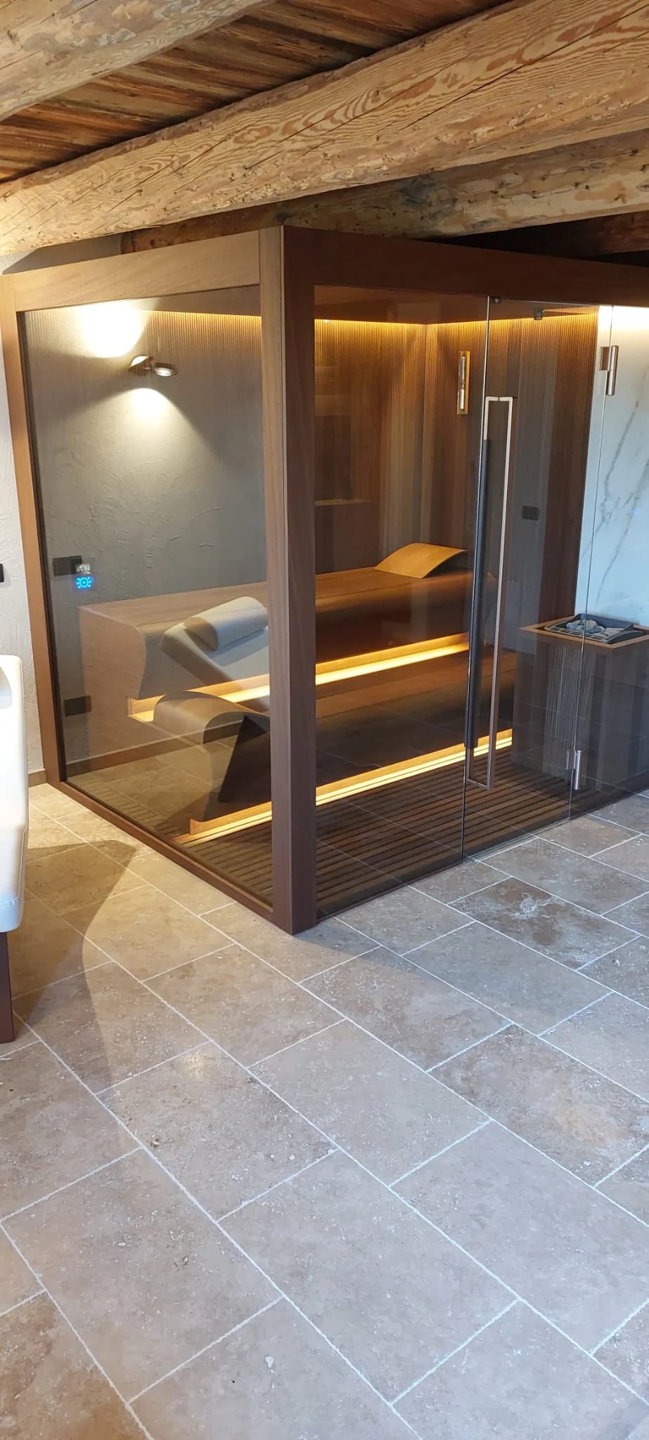 Full-height glass front and illuminated benches of an INFINITY Sauna