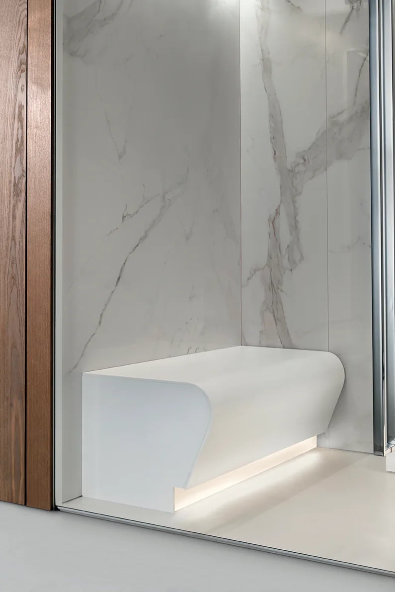 Warm concealed lighting beneath an INFINITY Steam Room bench