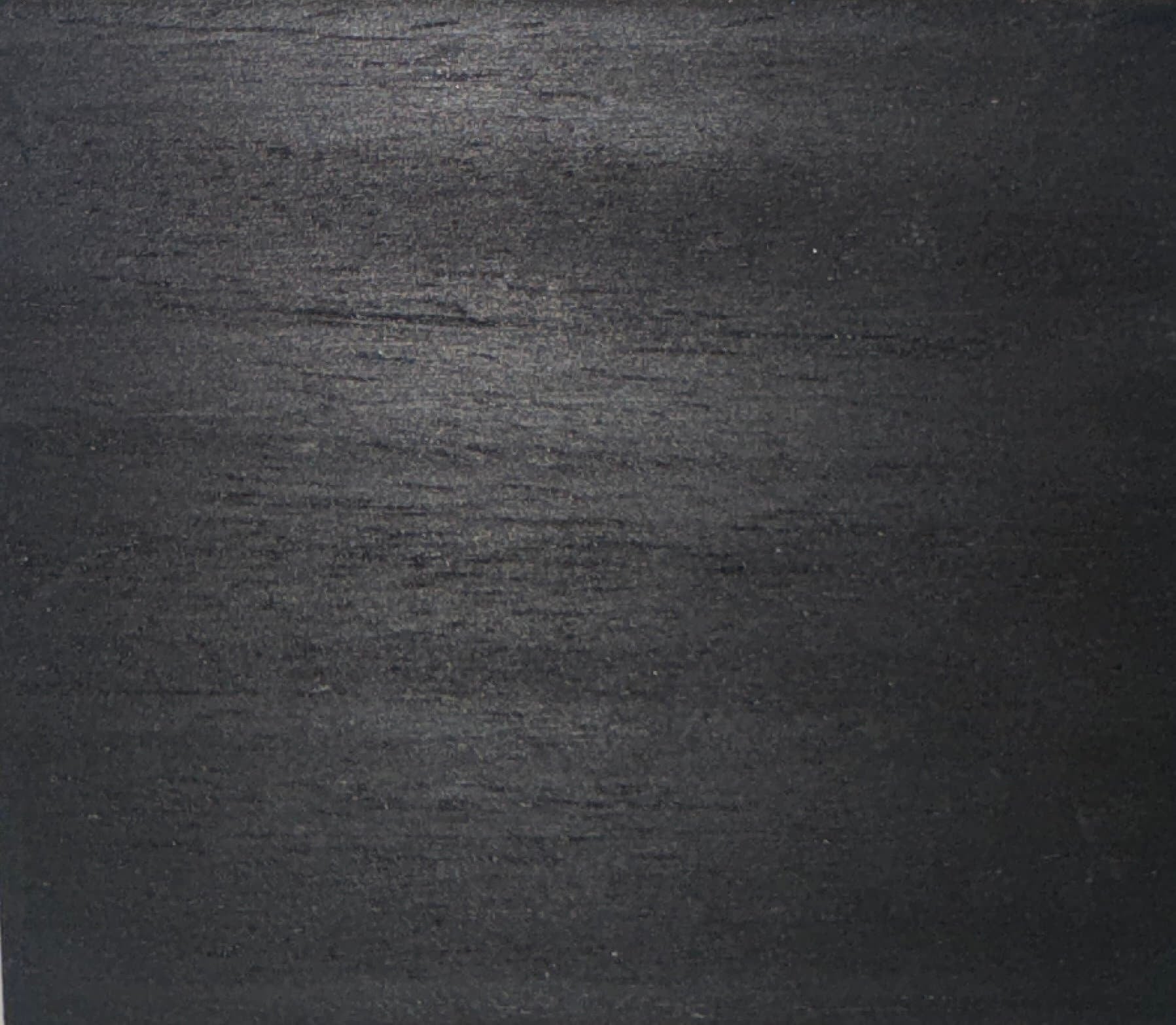 Close-up view of a dark, textured surface, possibly wood or metal.