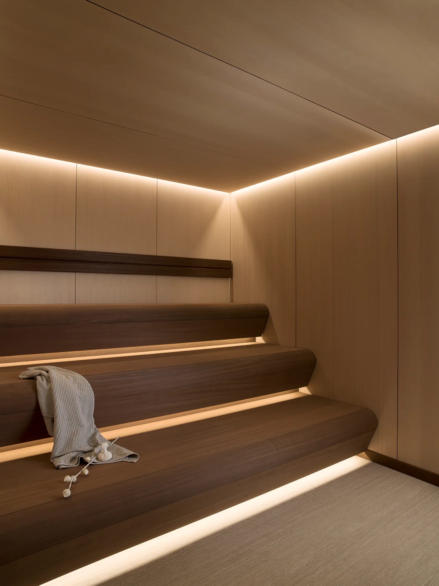 Warm timber Sauna with suspended benches and concealed lighting